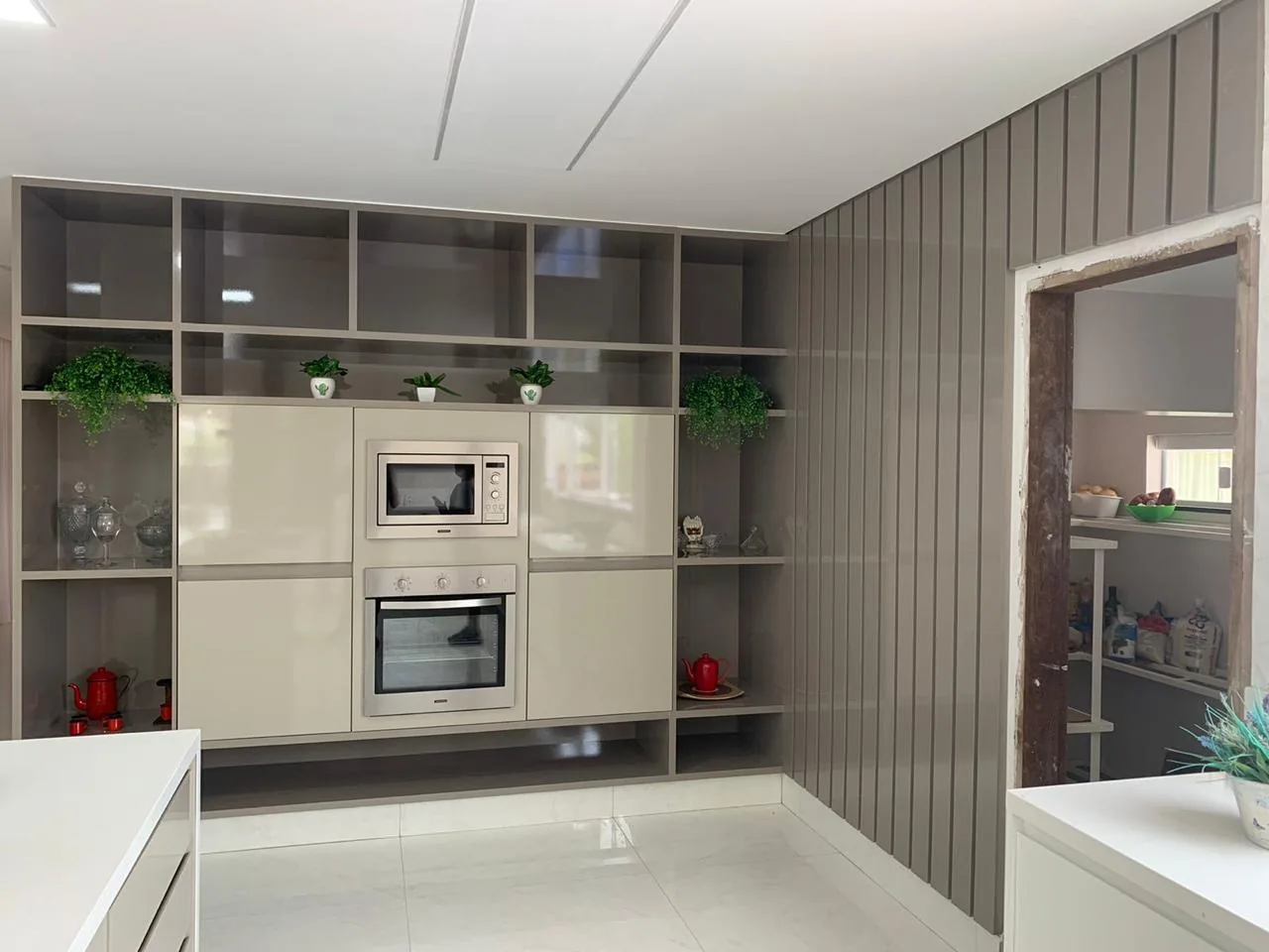 Cozinha com nichos abertos, forno e micro-ondas embutidos em torre