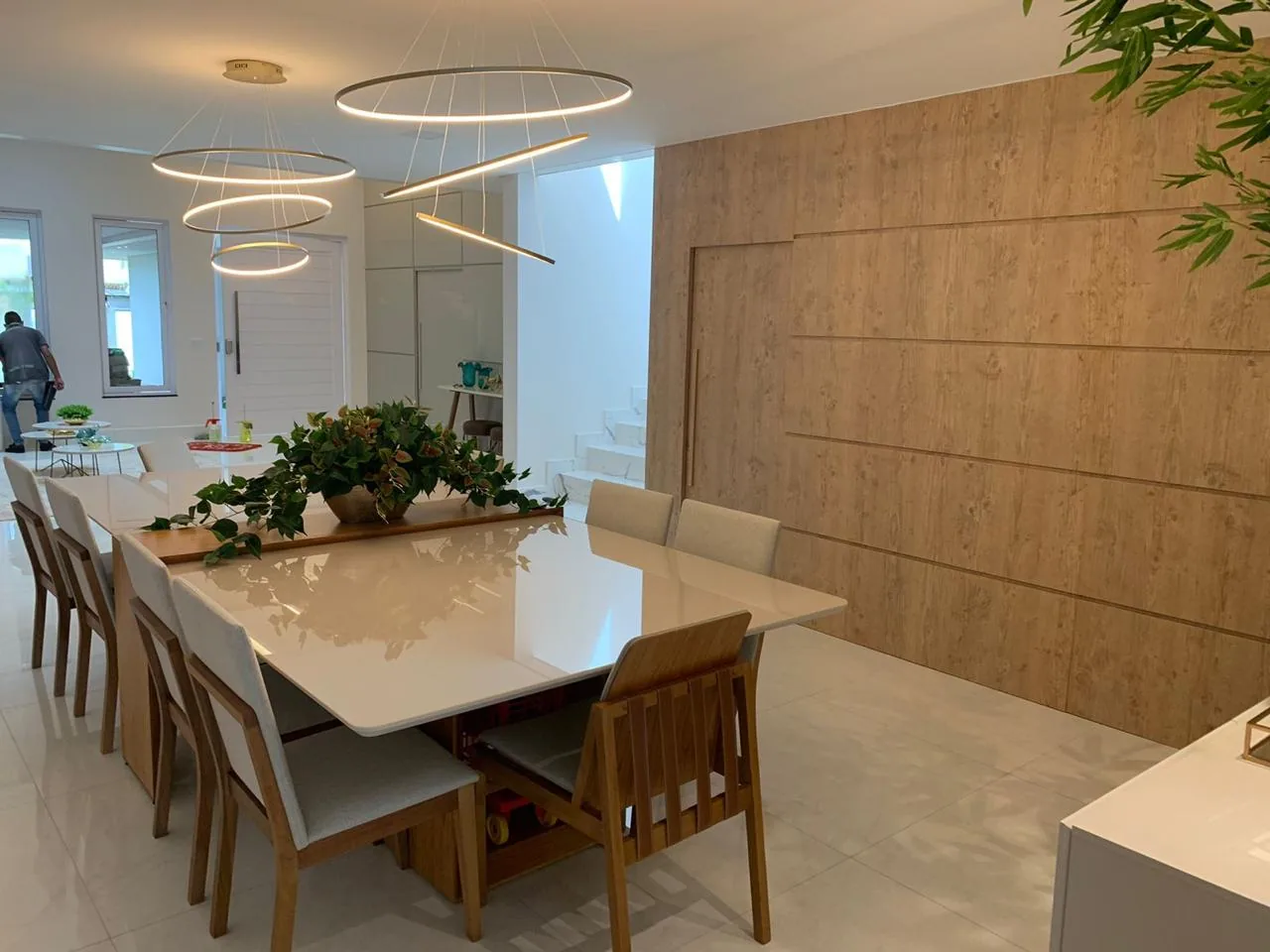 Mesa de jantar em pedra clara diante de painel ripado de madeira